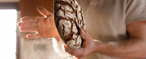 Cette image montre un artisan boulanger dans son atelier. Son but est de montrer que Panelconstruct s'adresse aussi à des artisans pour remettre aux normes les murs et plafonds de leurs ateliers.